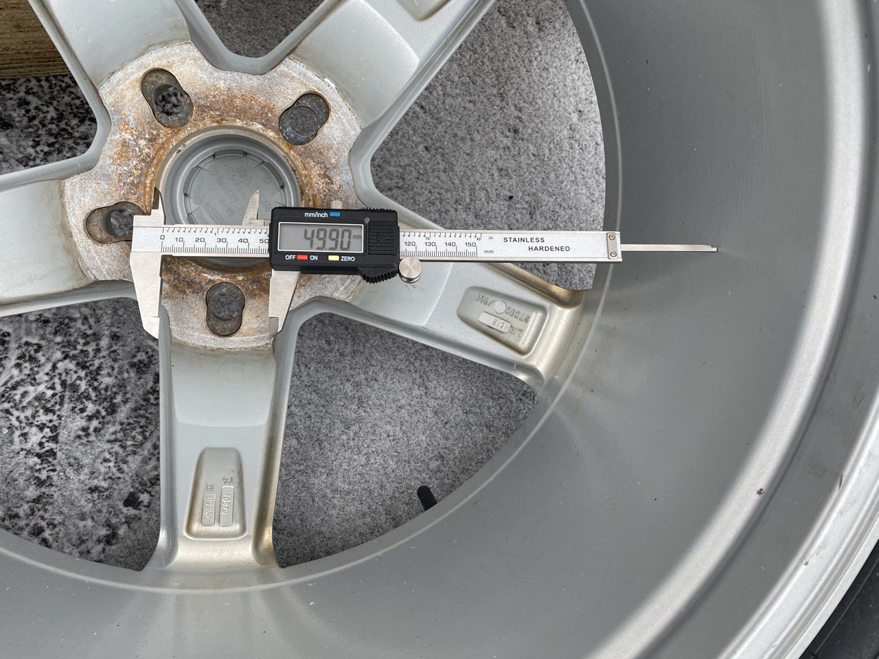 Measuring the wheel center bore with calipers